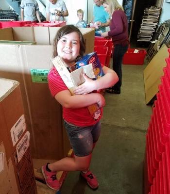 Young volunteer helping at Stamp Out Hunger drive